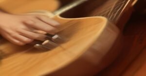 A close-up view of a guitarist practicing finger placement on the fretboard of an acoustic guitar.