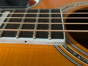 Professional luthier inspecting guitar frets