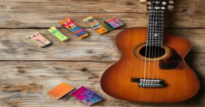 A beginner-guitar setup with an acoustic instrument and essential accessories on a wooden table.