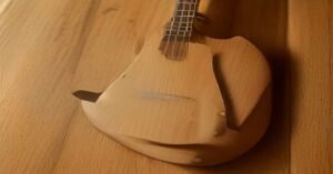 A close up view of a guitar neck and fretboard showing strings and frets.