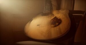 A vintage acoustic guitar in a cozy, sunlit practice room.